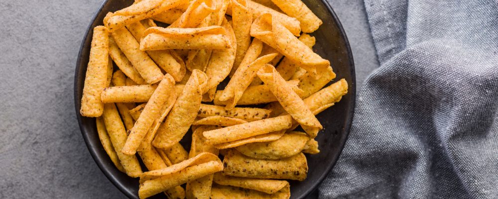 Rolled nachos tortilla chips on plate on a kitchen table. Top view.