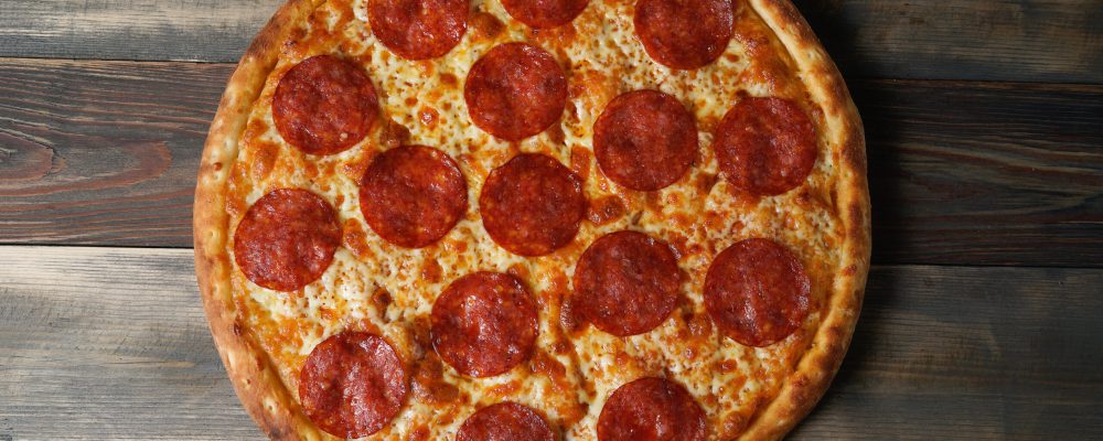 From above shot of crispy delicious classical pepperoni pizza.