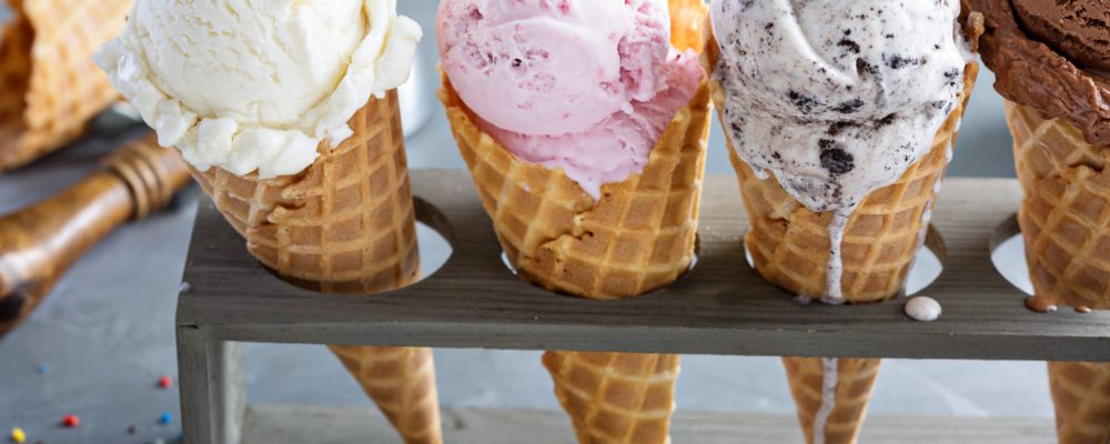 Variety of ice cream scoops in cones with chocolate, vanilla and strawberry