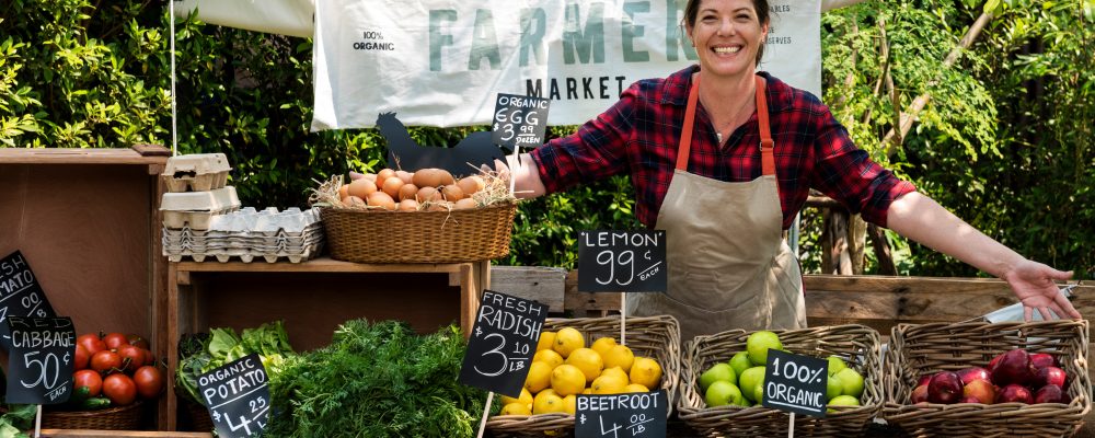 Greengrocer selling organic fresh agricultural product at farmer market