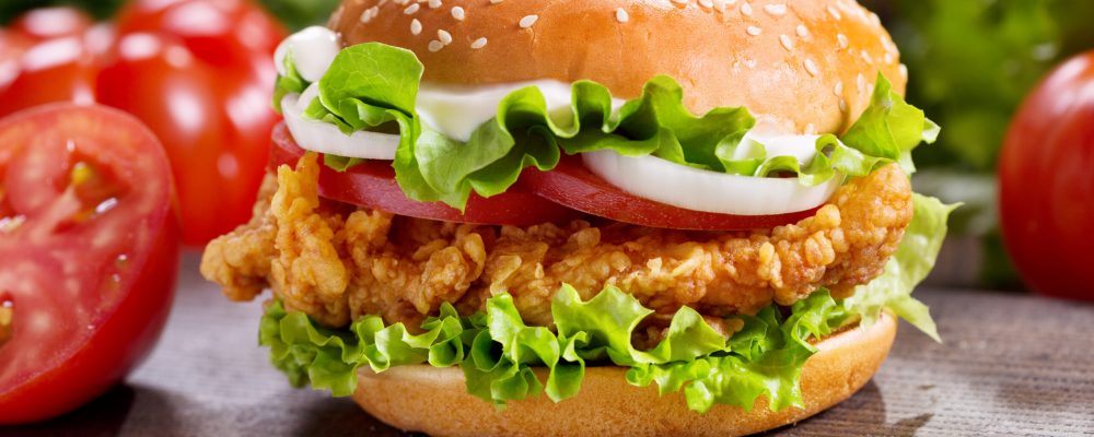 chicken burger with vegetables on a wooden table