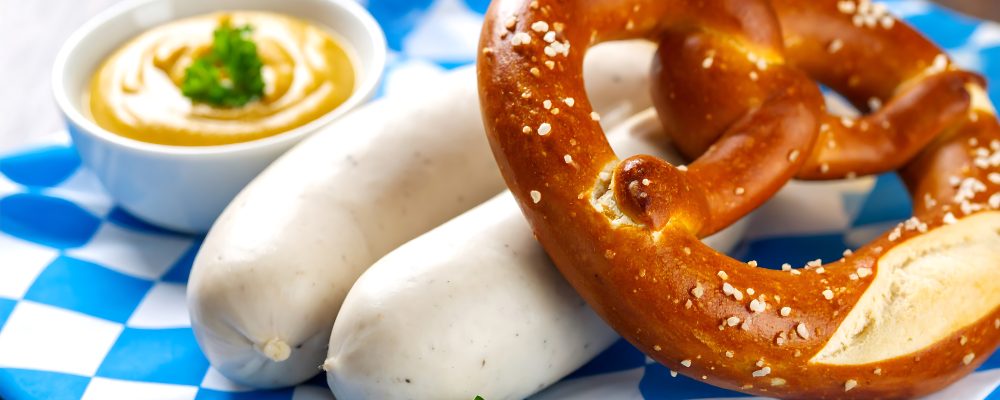 Bavarian pretzels and sausages on checkered cloth with mustard