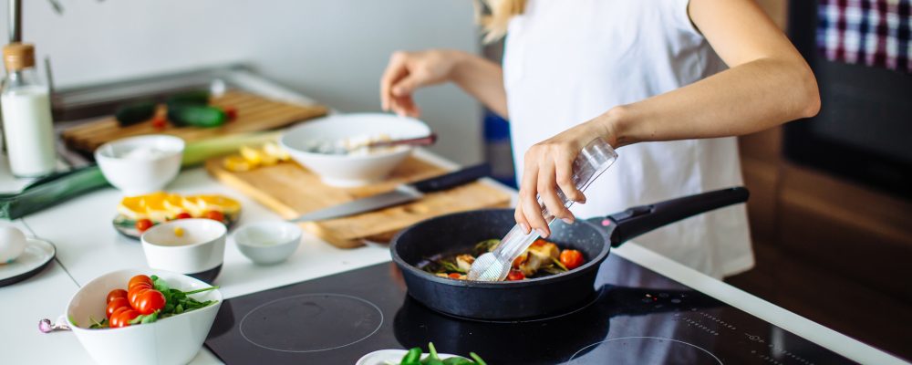 Young blonde woman cooking in the kitchen. Healthy Food. Dieting Concept. Healthy Lifestyle. Cooking At Home. Prepare Food
