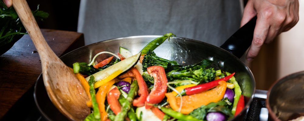 Japanese woman cooking stir fried vegetables