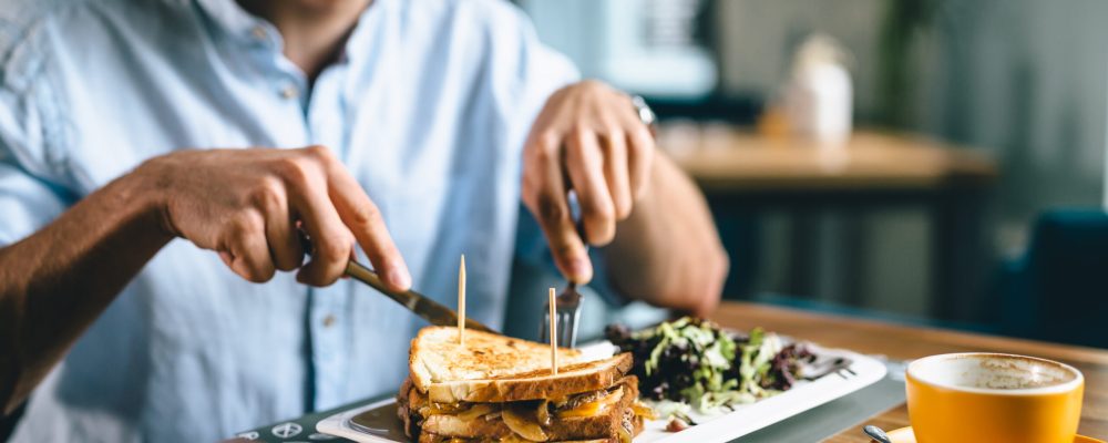 closeup of man eating dinner or breakfast in restaurant