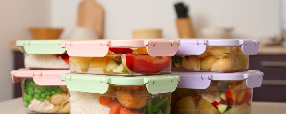 Boxes with prepared meals on table against blurred background