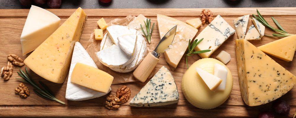 Flat lay composition with different types of delicious cheese on table
