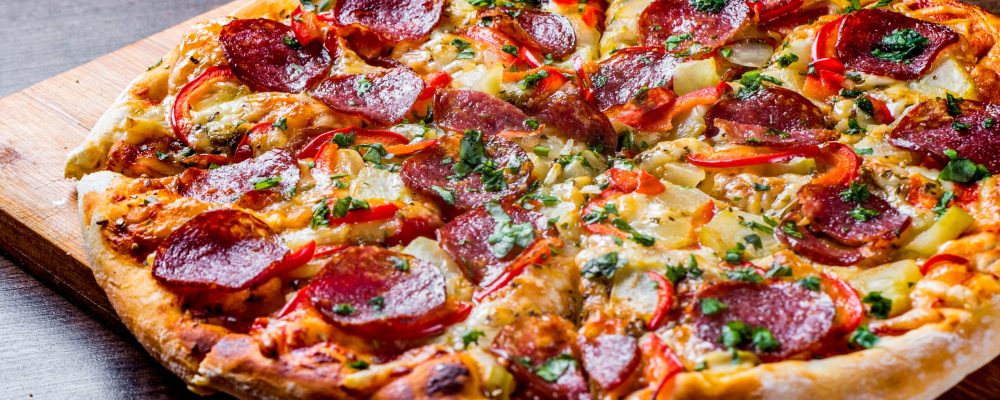 Pepperoni Pizza with Mozzarella cheese, salami, pepper. Spices and Fresh basil. Italian pizza on wooden table background
