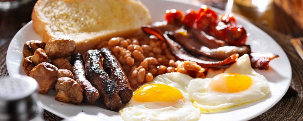 english breakfast with eggs, tomatoes, mushrooms, bacon, beans, and sausage