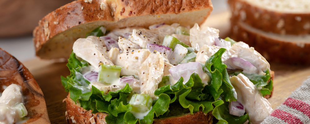 Closeup of chicken salad sandwich with lettuce on whole grain bread