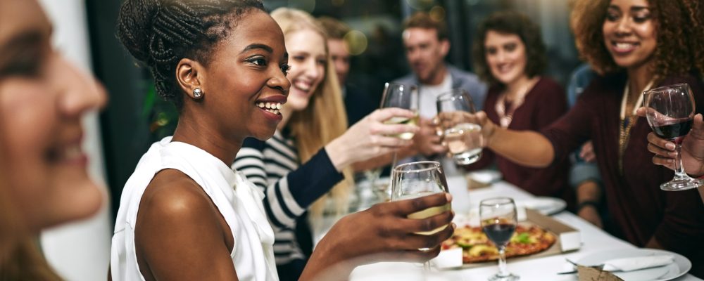 Diversity, dinner and group of people toast celebration together at party. Friends, happy and celebrate with food, wine and friendship for love, support and cheers champagne at business function.