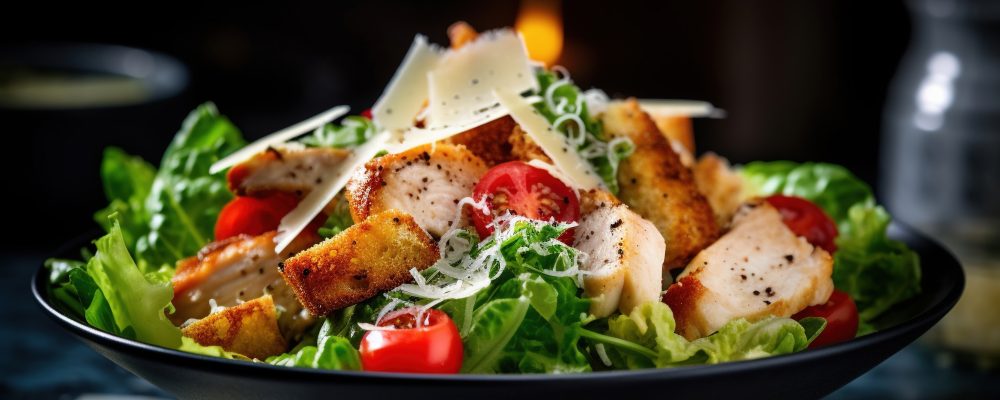 A delicious chicken caesar salad with parmesan cheese, tomatoes, croutons and dressing