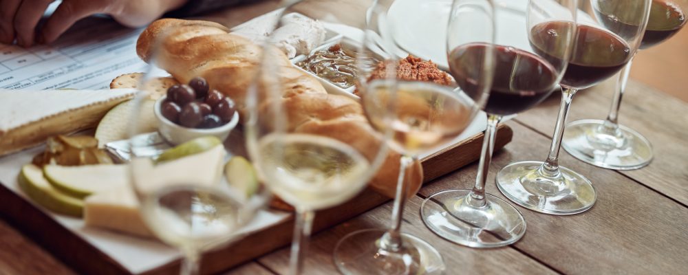 Wine tasting, cheese board and winery restaurant with alcohol and glass for customer. Eating, drink and person with rich wines and food pairing in a fine dining and luxury snack experience alone.