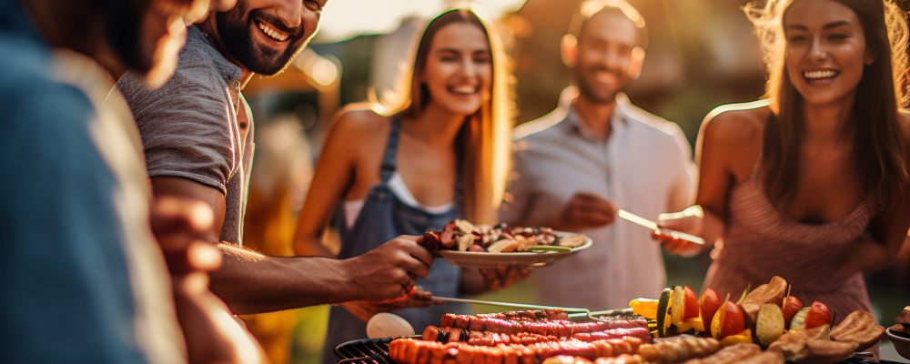 Friends socializing and enjoying a backyard BBQ, grilling food at a summer cookout