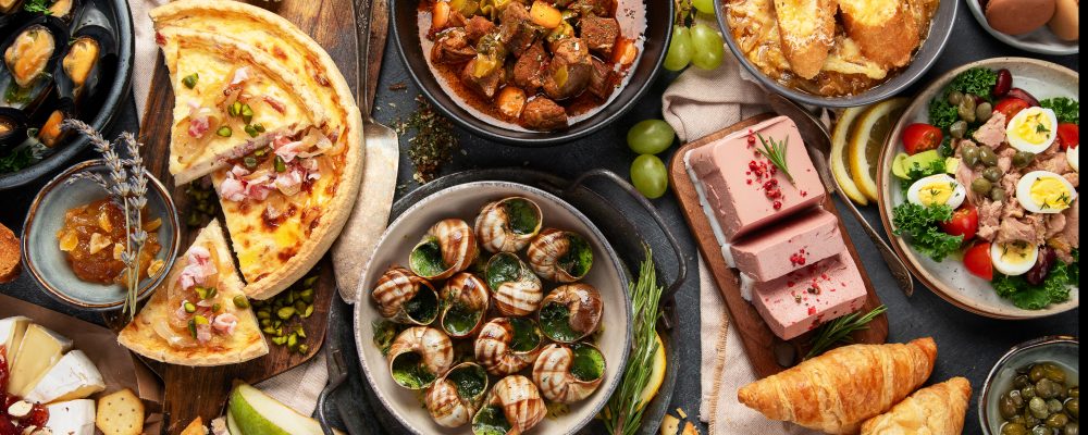 French food assortment on dark background. Traditional cuisine concept. Top view.