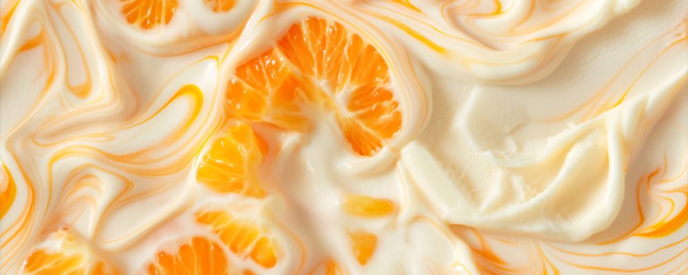 top view of orange creamsicle ice cream surface, a closeup of the orange creamsicle ice cream texture, featuring its creamy base with a bright orange color and swirls of vanilla