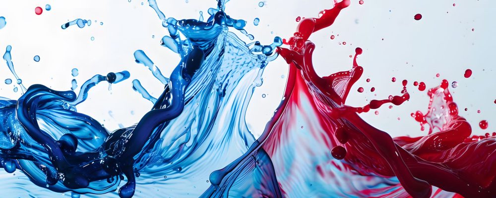 A close up of red and blue liquid splashing on a white surface