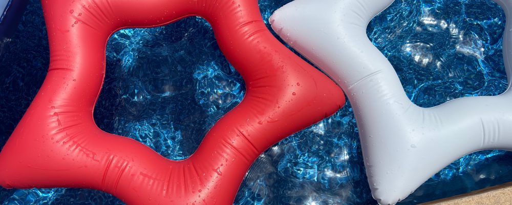 Colorful star-shaped pool floats in blue water on a sunny day