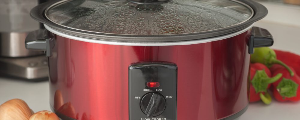 Close up of a slow cooker working on kitchen shelf